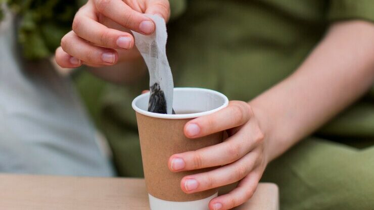 Close up woman taking tea bag out cup 23 2148672920